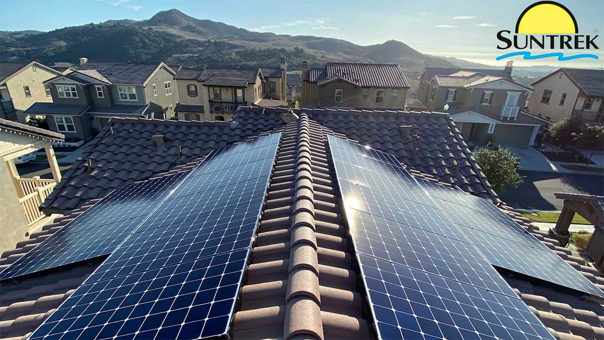 Aerial shot of residential rooftops featuring multiple solar panels installed.