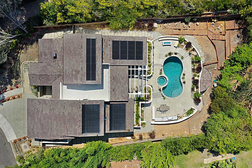 Aerial view of a home equipped with solar energy systems, showcasing rooftop solar panels.