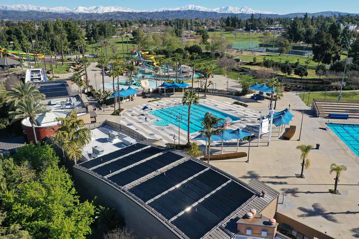 Aerial view of a resort with backyard pools and solar panels on rooftops