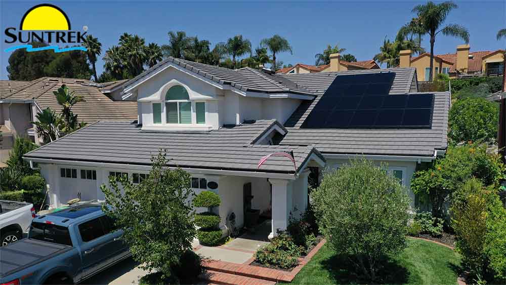 Residential house with solar panels installed on the roof under clear skies