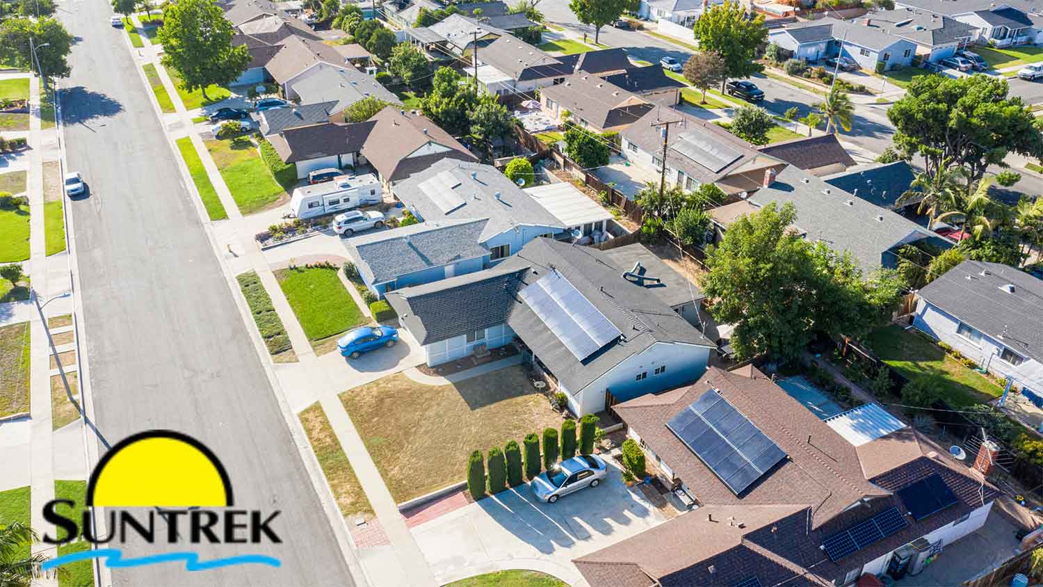 Top-down view of a suburban neighborhood featuring rooftop solar panel systems