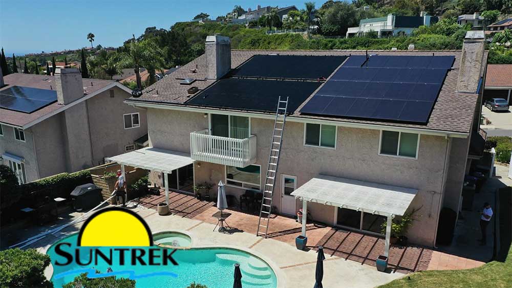 Backyard view of a residential home with a swimming pool, solar panels visible on the roof