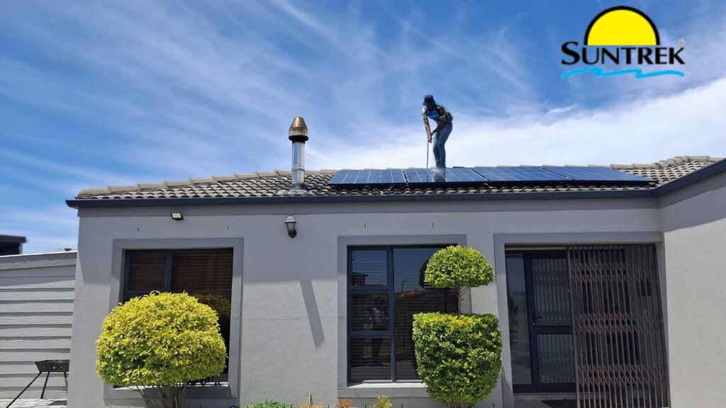 Technician on a rooftop inspecting solar panels.