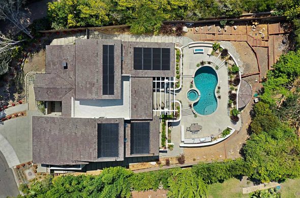 Aerial view of a home equipped with solar energy systems, showcasing rooftop solar panels.