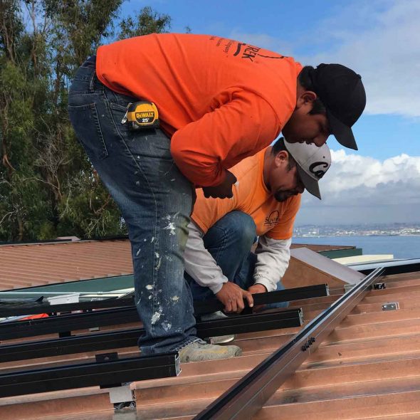Two Suntrek technicians working on solar panel installation
