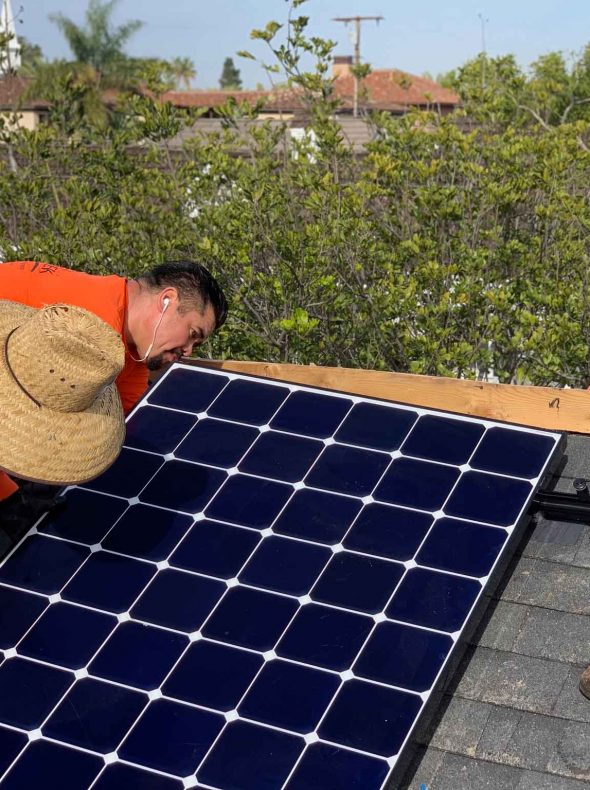 A team of technicians installing a solar panels on a rooftop.