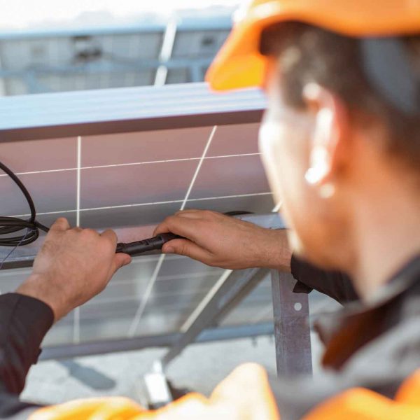 Professional solar installer adjusting rooftop panels