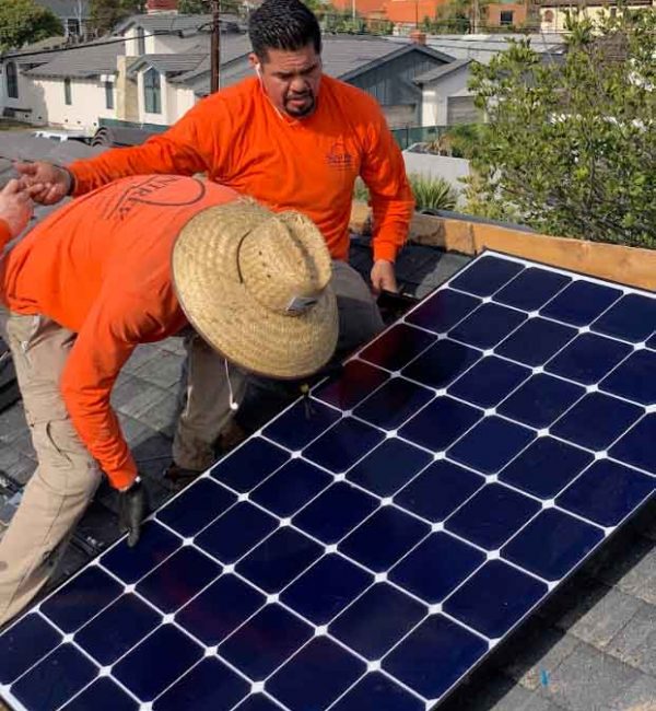 Technicians conducting a solar panel installation on the roof.